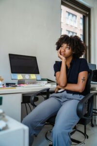 Young woman deep in thought at a modern office desk. Ideal for themes of work and creativity.