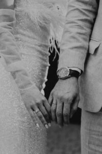 Embrace the essence of love with this touching wedding photograph showing a couple holding hands.