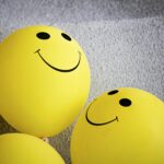Three yellow smiley face balloons creating a cheerful and bright atmosphere indoors.