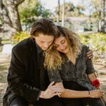 A comforting embrace in a serene graveyard captures grief and support.