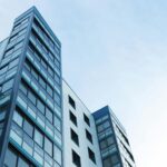 Low-angle view of a modern glass skyscraper against a clear sky in Poole, UK.