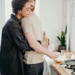 Young couple embracing in a cozy kitchen, sharing a moment of love and affection.