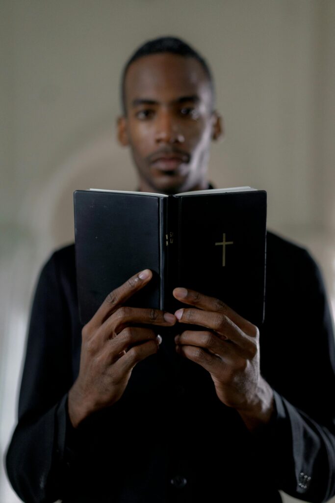 Focused African man holding a religious book, symbolizing faith and spirituality.