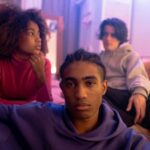 Group of diverse teenagers relaxing and bonding in a cozy bedroom setting.