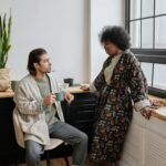 Couple enjoying morning coffee and conversation in cozy home setting.