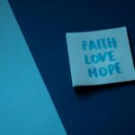 A blue note on contrasting backgrounds displaying the words faith, love, and hope.