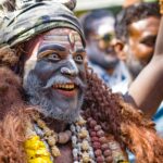 Captivating portrait of a man in traditional attire during Masaan Holi festival in Varanasi, India.