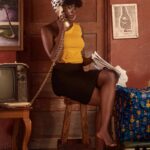 A stylish woman in a retro setting talks on a landline phone, embodying vintage charm.