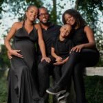 Happy family posing outdoors with a warm smile, surrounded by nature.