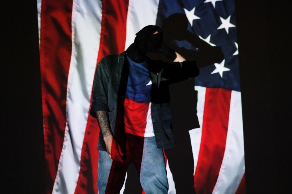 Silhouette posing with American flag backdrop symbolizing patriotism and creativity.